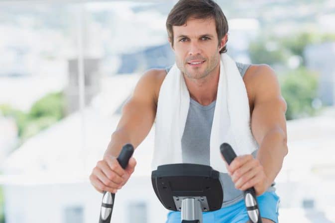 Homme sur vélo d'appartement